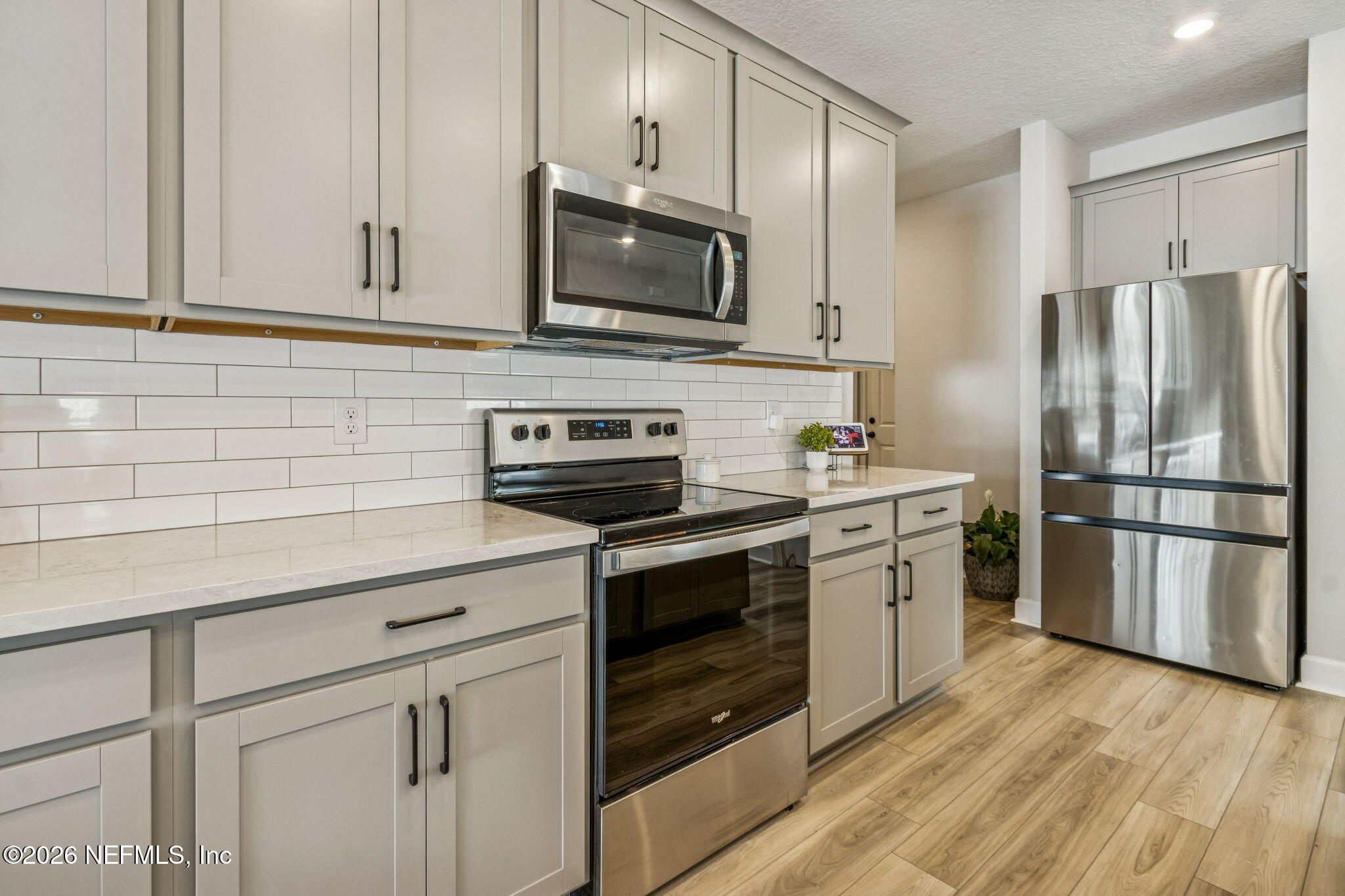 95057 Terris Way Fernandina Beach, FL 32034 - Photo 15 of 43 a kitchen with stainless steel appliances white cabinets and wooden floor