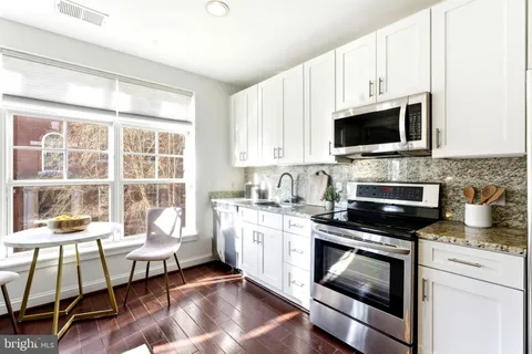 a kitchen with a stove a sink and a microwave