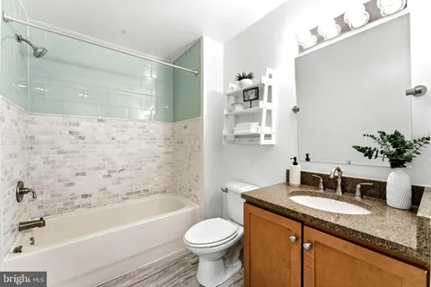 a bathroom with a granite countertop sink toilet and shower