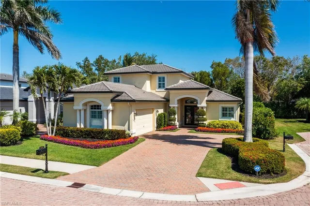 a front view of a house with a yard and potted plants