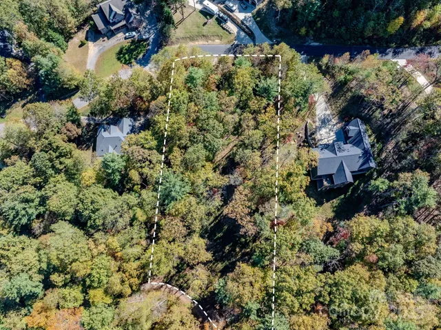 an aerial view of residential house with outdoor space and trees all around