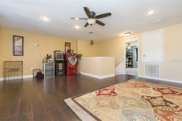 a view of a livingroom with furniture wooden floor and a ceiling fan