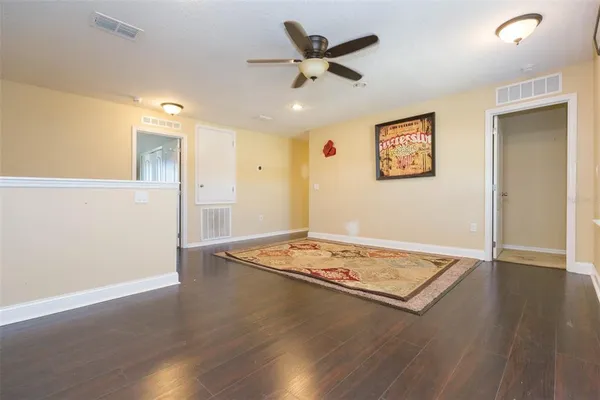 a view of an empty room with wooden floor