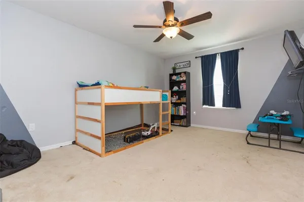a bedroom with furniture and a ceiling fan