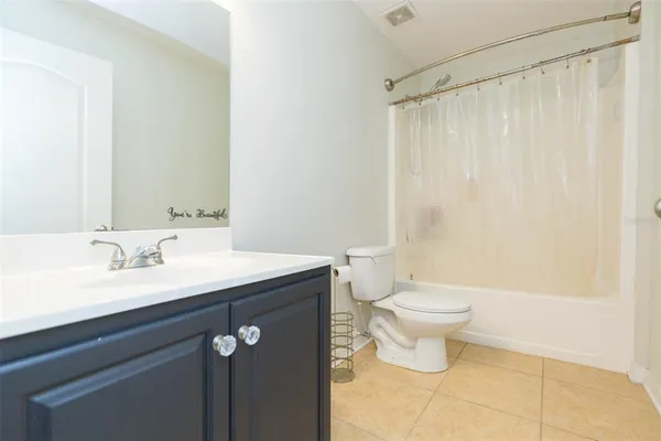 a bathroom with a granite countertop sink a toilet and a mirror