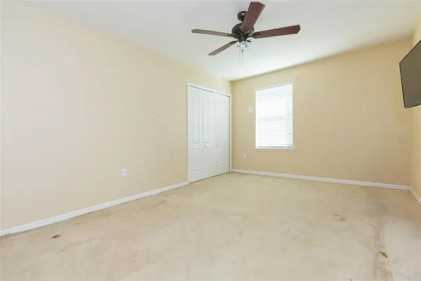an empty room with a window and a fan