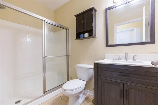 a bathroom with a granite countertop sink toilet a mirror and shower