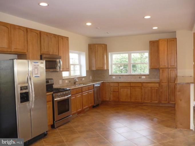 5224 Inverchapel Road Springfield, VA 22151 - Photo 5 of 30 a kitchen with stainless steel appliances granite countertop a refrigerator a sink a stove with wooden cabinets