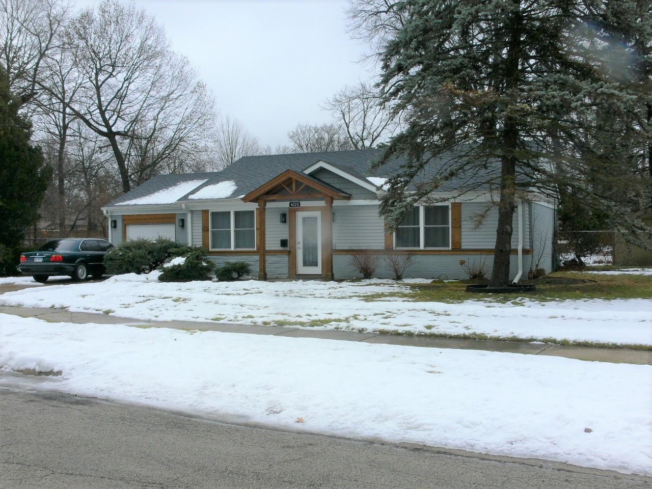 4223 Ostrander Road Rockford, IL 61107 - Photo 1 of 20 a front view of a house with a yard covered in snow