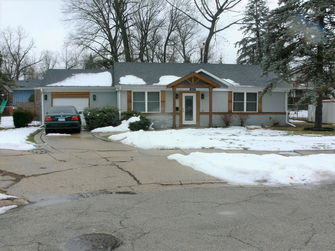 4223 Ostrander Road Rockford, IL 61107 - Photo 2 of 20 a front view of a house with a yard covered with snow and trees