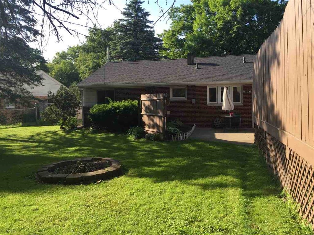4223 Ostrander Road Rockford, IL 61107 - Photo 3 of 20 a view of a backyard with table and chairs potted plants and large tree