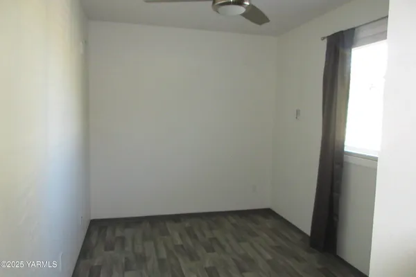 a view of small space with wooden floor and a window