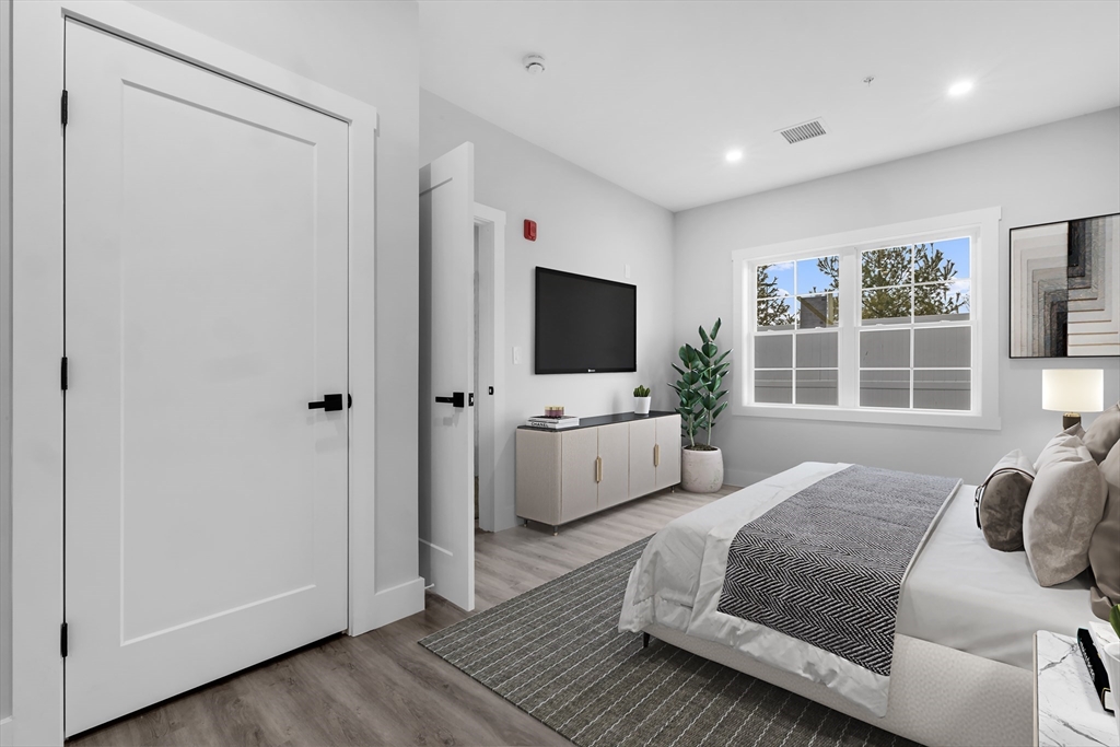889-895 Grinnell Street, Unit 7 Fall River, MA 02721 - Photo 5 of 37 a spacious bedroom with a large bed and a flat screen tv