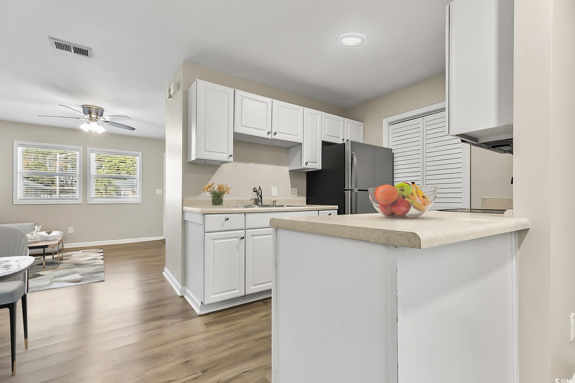 4150 Horseshoe Road North, Unit 38 Little River, SC 29566 - Photo 7 of 29 Kitchen with light countertops, white cabinets, light wood-style floors, and a ceiling fan