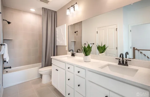 a bathroom with a double vanity sink toilet and shower