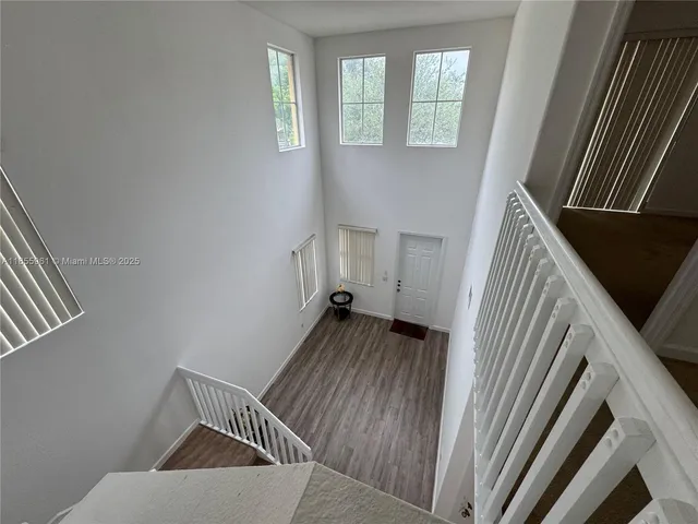 front view of house with a yard and palm trees