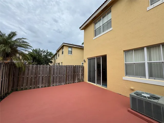 a view of a house with a yard and palm trees
