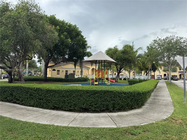 a view of a yard with plants and trees