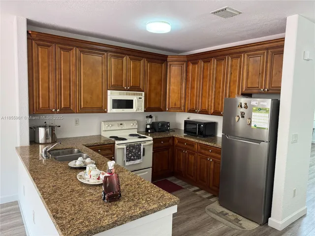 a kitchen with stainless steel appliances granite countertop a stove microwave and refrigerator