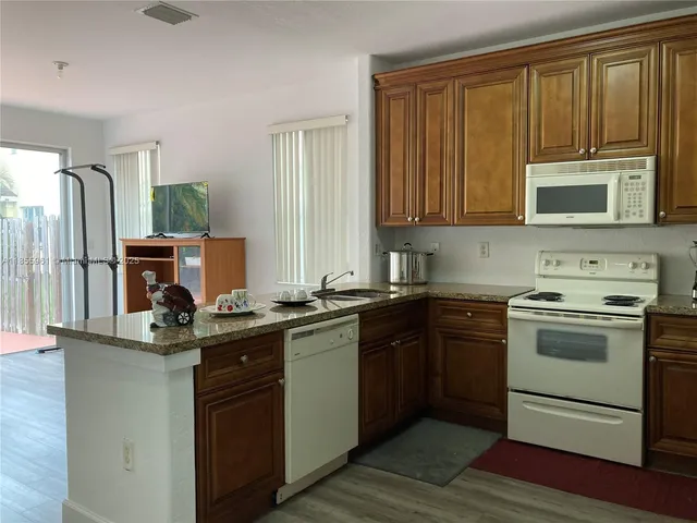 a view of a livingroom with wooden floor and a flat screen tv