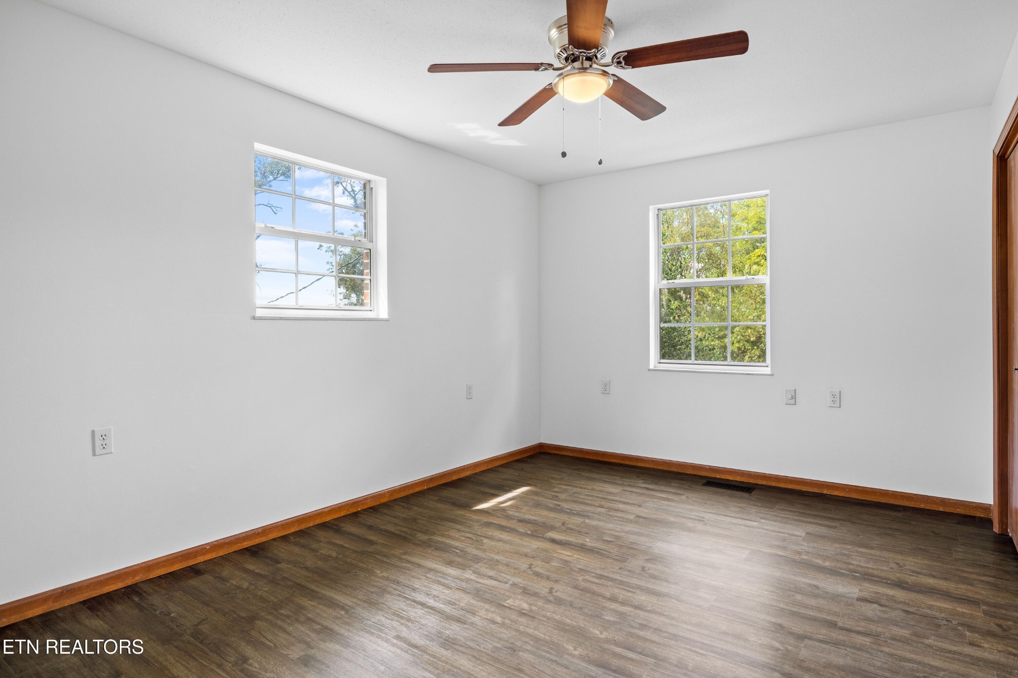 804 Chilhowee View Road Maryville, TN 37803 - Photo 22 of 38 an empty room with wooden floor chandelier fan and windows