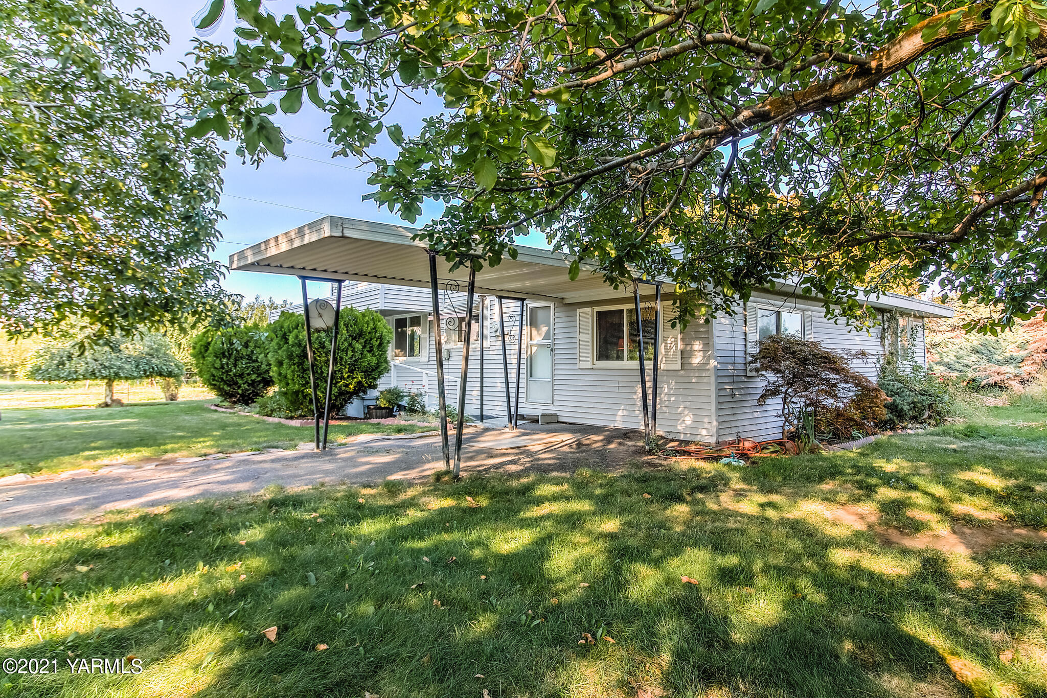 a view of a house with backyard and tree