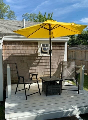 1061 State Highway, Unit 4 Eastham, MA 02642 - Photo 16 of 27 a view of a roof deck with table and chairs under an umbrella