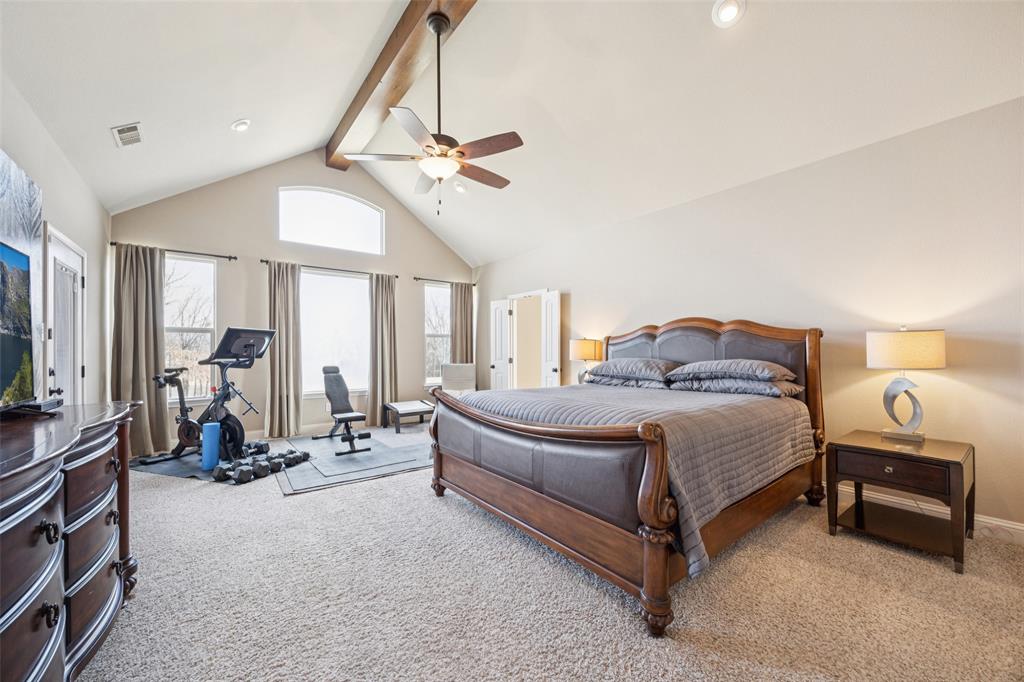 370 Private Road 5291 Yantis, TX 75497 - Photo 14 of 40 a spacious bedroom with a bed a chandelier and a flat screen tv