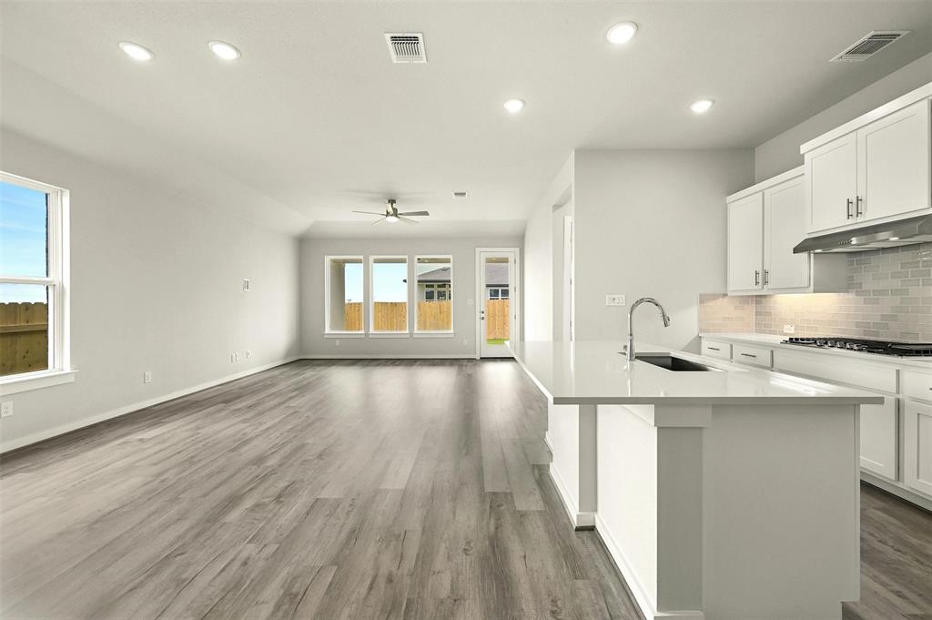 4304 Contrail Lane Round Rock, TX 78665 - Photo 5 of 13 a kitchen with stainless steel appliances granite countertop a sink a stove and a wooden floors