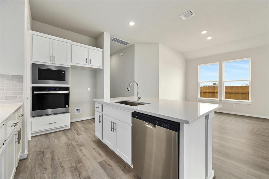 4304 Contrail Lane Round Rock, TX 78665 - Photo 7 of 13 a kitchen with stainless steel appliances a stove sink and microwave