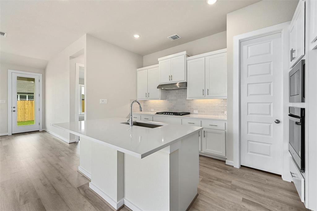 4304 Contrail Lane Round Rock, TX 78665 - Photo 8 of 13 a kitchen with stainless steel appliances a sink and wooden floor
