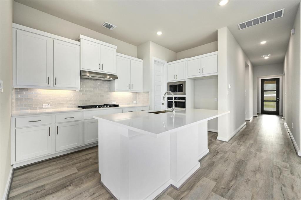 4304 Contrail Lane Round Rock, TX 78665 - Photo 9 of 13 a kitchen with granite countertop white cabinets and white appliances