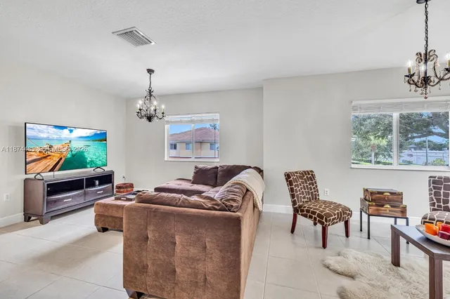 a living room with furniture a flat screen tv and a window