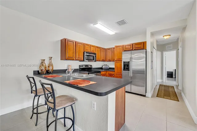 a kitchen with stainless steel appliances granite countertop a sink a stove and a refrigerator