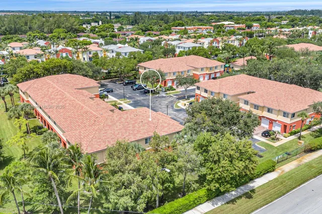 an aerial view of residential houses with outdoor space and trees