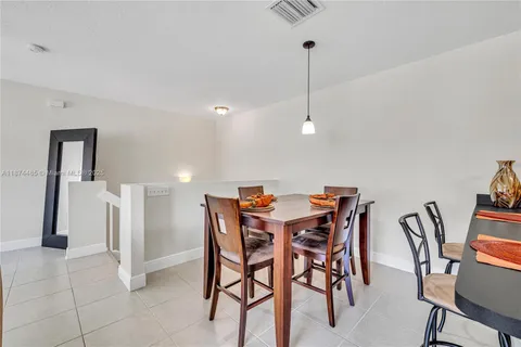a view of kitchen with refrigerator stove dining table and chairs