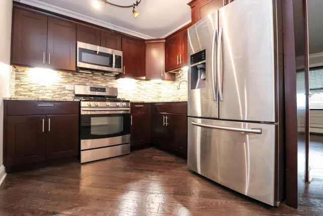 a kitchen with granite countertop stainless steel appliances and wooden cabinets