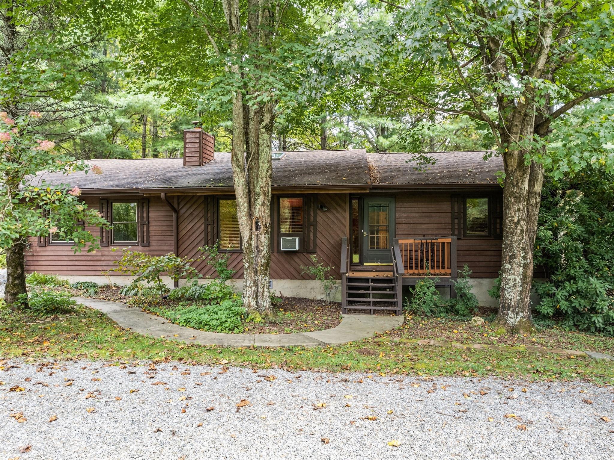 182 Laurel Branch Road Maggie Valley, NC 28751 - Photo 2 of 48 a front view of a house with garden