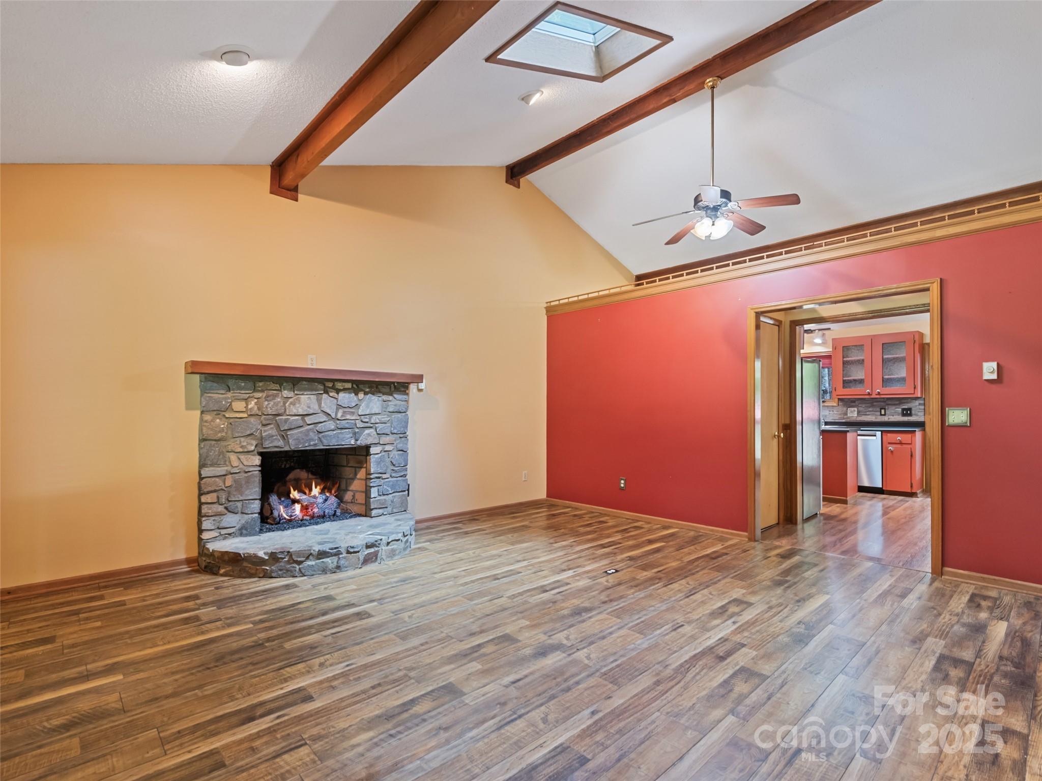182 Laurel Branch Road Maggie Valley, NC 28751 - Photo 23 of 48 a view of an empty room with wooden floor fireplace and a window