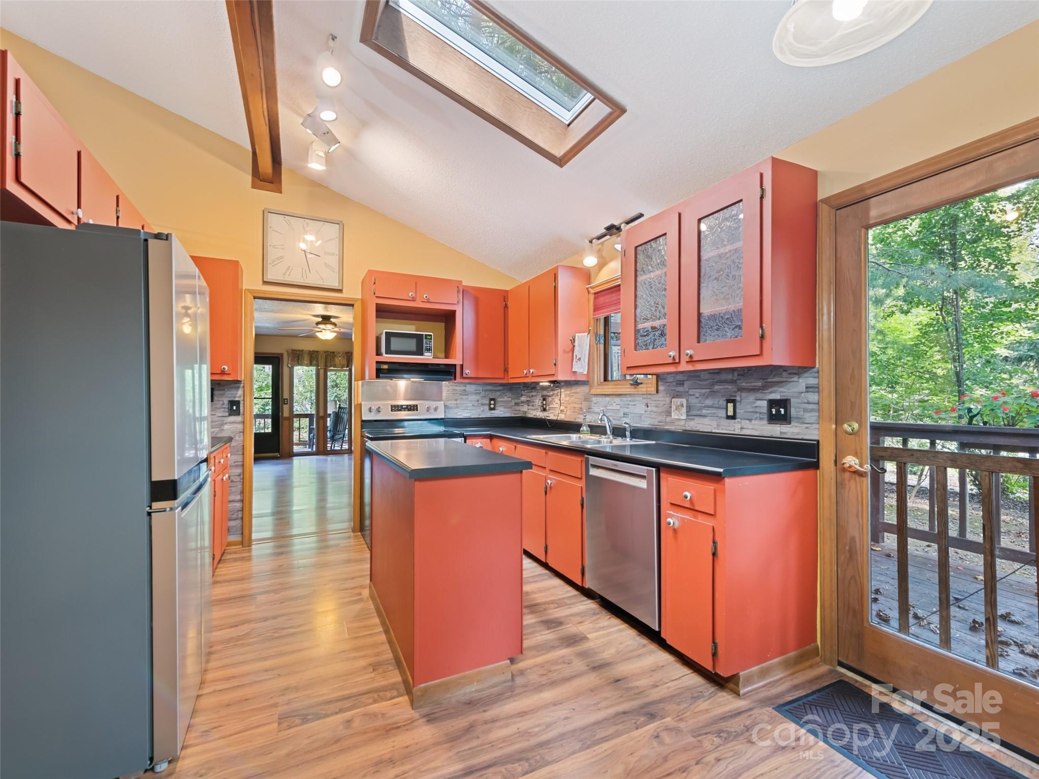 182 Laurel Branch Road Maggie Valley, NC 28751 - Photo 24 of 48 a kitchen with stainless steel appliances granite countertop a refrigerator a stove top oven a sink and wooden floors