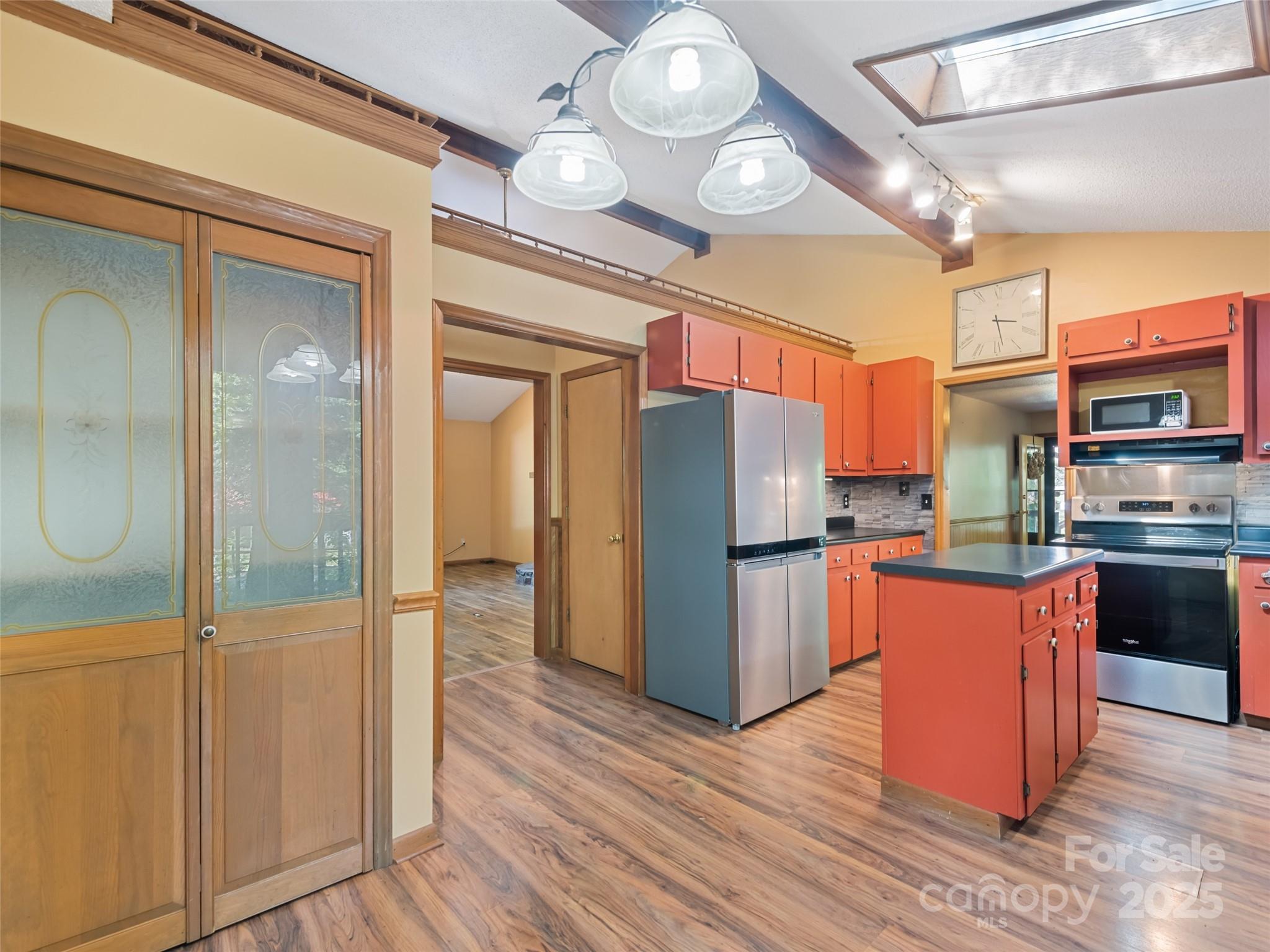 182 Laurel Branch Road Maggie Valley, NC 28751 - Photo 25 of 48 a kitchen with stainless steel appliances granite countertop a refrigerator a stove top oven a sink and dishwasher with wooden floor