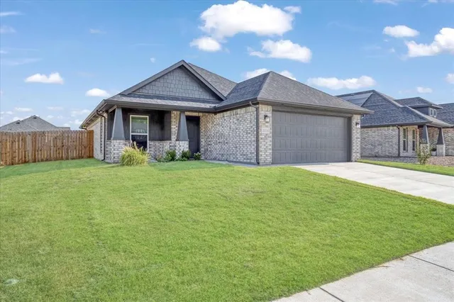 a front view of a house with yard and green space