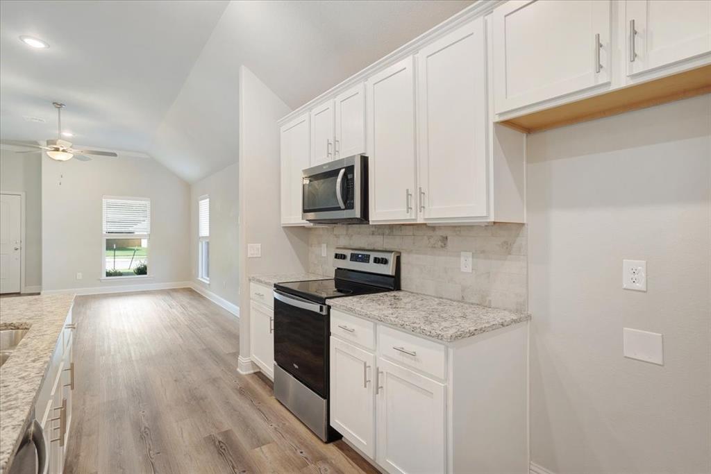 2111 Wyldewood Way Sherman, TX 75092 - Photo 13 of 33 a kitchen with stainless steel appliances granite countertop a stove a sink and a microwave