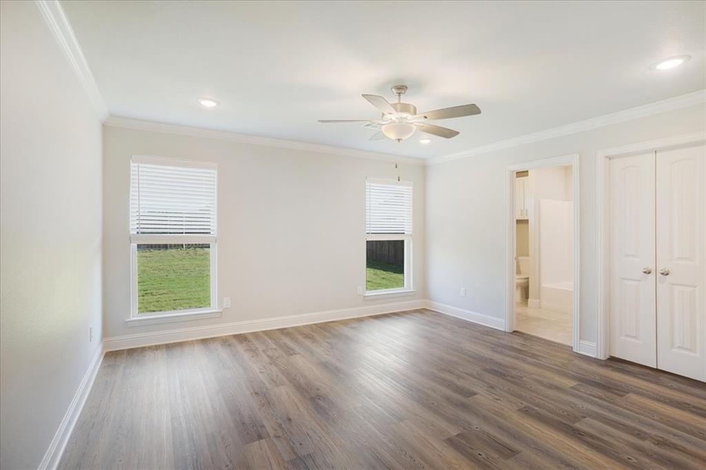 2111 Wyldewood Way Sherman, TX 75092 - Photo 15 of 33 an empty room with wooden floor chandelier fan and windows