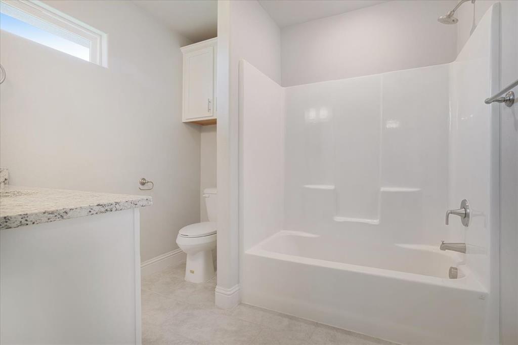 2111 Wyldewood Way Sherman, TX 75092 - Photo 18 of 33 a bathroom with a bathtub and a toilet