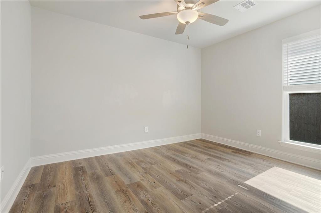 2111 Wyldewood Way Sherman, TX 75092 - Photo 21 of 33 an empty room with a window and a ceiling fan