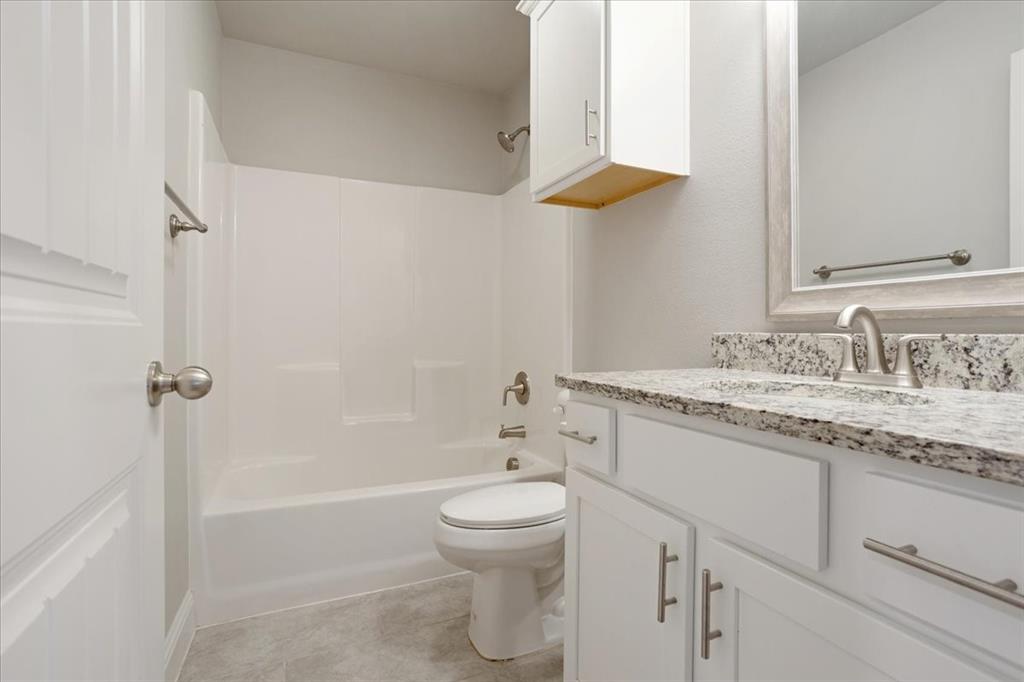 2111 Wyldewood Way Sherman, TX 75092 - Photo 24 of 33 a bathroom with a granite countertop sink a toilet and shower