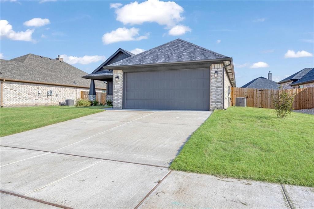 2111 Wyldewood Way Sherman, TX 75092 - Photo 3 of 33 a front view of a house with a yard and garage