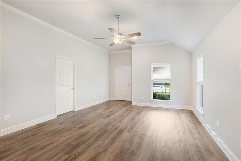 2111 Wyldewood Way Sherman, TX 75092 - Photo 6 of 33 an empty room with wooden floor chandelier fan and windows