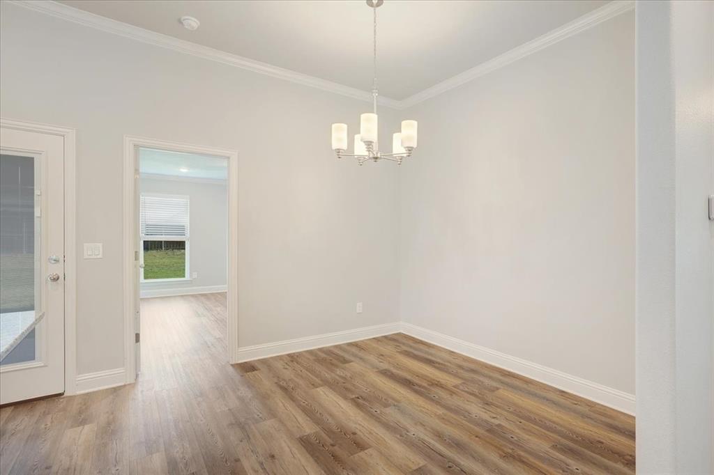 2111 Wyldewood Way Sherman, TX 75092 - Photo 10 of 33 an empty room with wooden floor and windows
